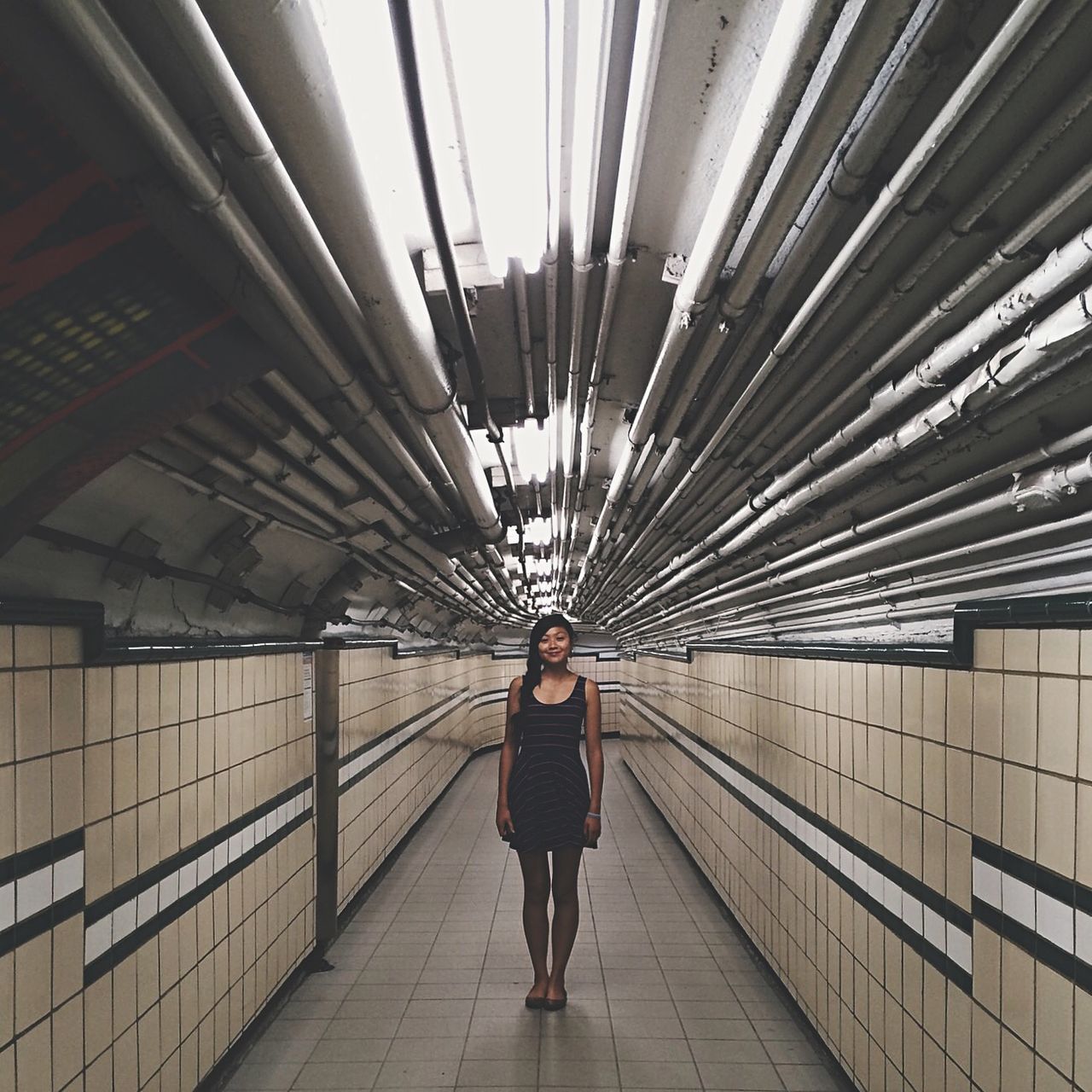 full length, lifestyles, rear view, walking, architecture, built structure, standing, leisure activity, casual clothing, indoors, men, person, the way forward, tunnel, railing, ceiling, day, travel