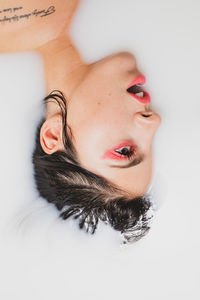 Close-up portrait of young woman lying down