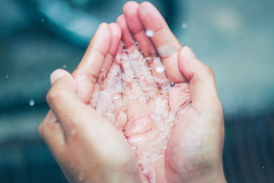 Close-up of person holding wet hand