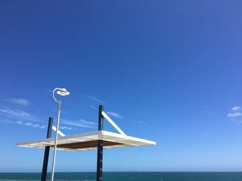 Low angle view of windmill against clear blue sky