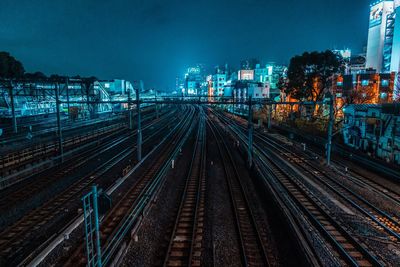 High angle view of railroad tracks amidst buildings at night