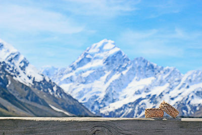 Close-up of bangles on railing against snowcapped mountain