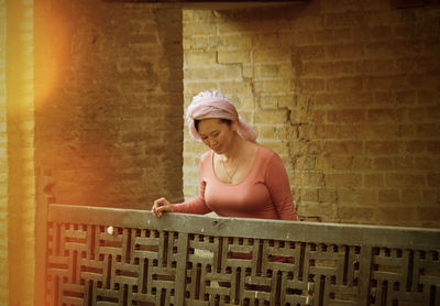 Woman looking down while standing by railing