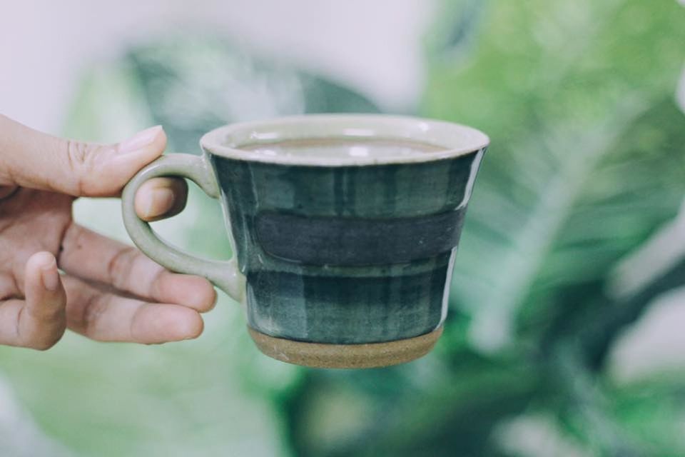 CLOSE-UP OF WOMAN HAND HOLDING COFFEE CUP