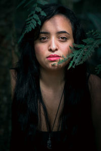 Close-up portrait of young woman in forest