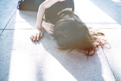 High angle view of woman lying down on footpath