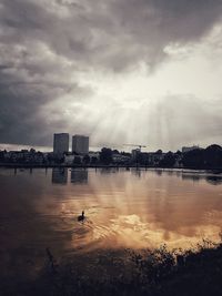 Scenic view of river by buildings against sky