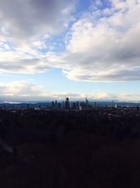 View of cityscape against cloudy sky