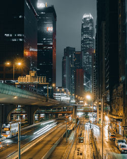 Illuminated street amidst buildings in city at night