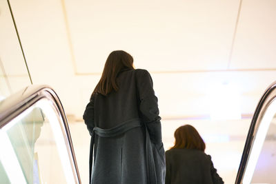 Rear view of people on escalator