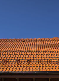 Low angle view of building roof against clear blue sky