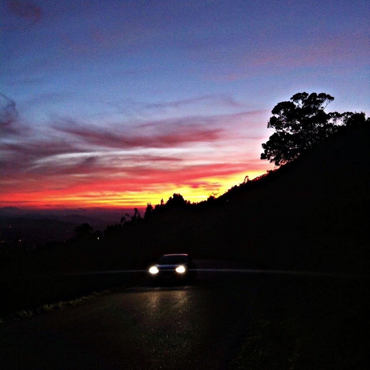 sunset, silhouette, sky, tree, scenics, tranquility, tranquil scene, mountain, beauty in nature, road, dusk, transportation, dark, cloud - sky, orange color, nature, landscape, cloud, idyllic, car