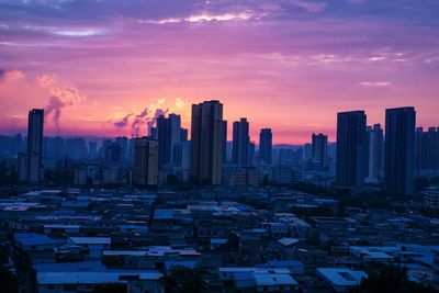 Aerial view of buildings in city against sky during sunset