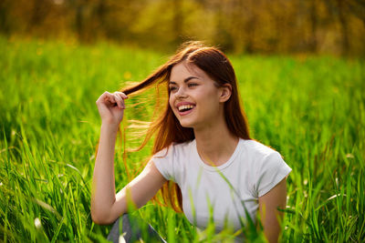 Rear view of woman with arms raised on field