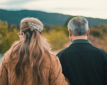 Rear view of mature couple standing outdoors