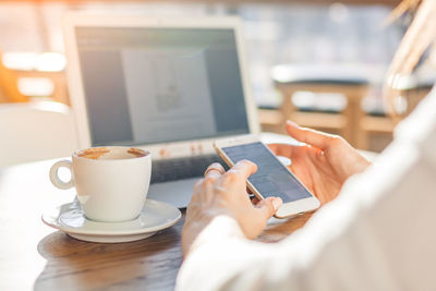 Man holding coffee cup on table