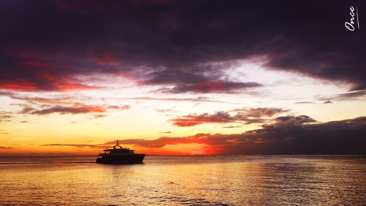 BOATS SAILING IN SEA AT SUNSET