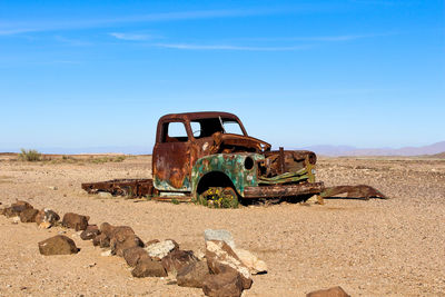 Abandoned truck on land against sky