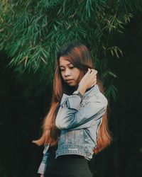 Beautiful young woman standing against plants