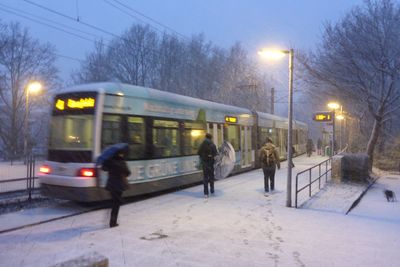 People on snow covered road at night