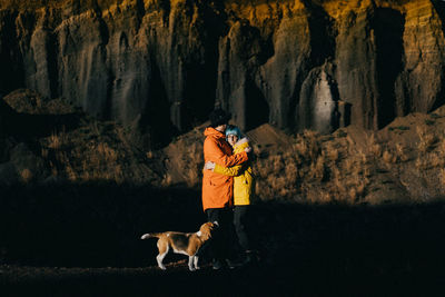 Dog walking on rock and a coule in love