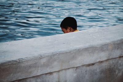 Rear view of man swimming in pool