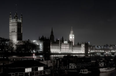 Illuminated buildings in city against sky at night