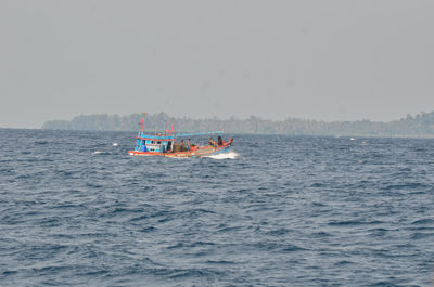 Boat sailing in sea against sky