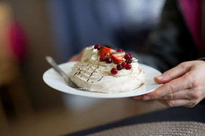 Cropped image of person holding dessert in plate