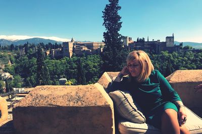 Thoughtful woman looking away while sitting on building terrace