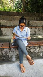 Full length of young woman sitting outdoors