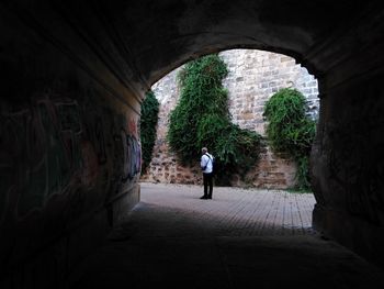 Rear view of man walking in tunnel