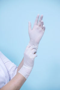 Midsection of woman holding hands against blue background