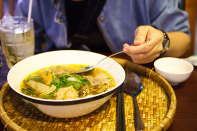 Cropped image of woman having pho soup