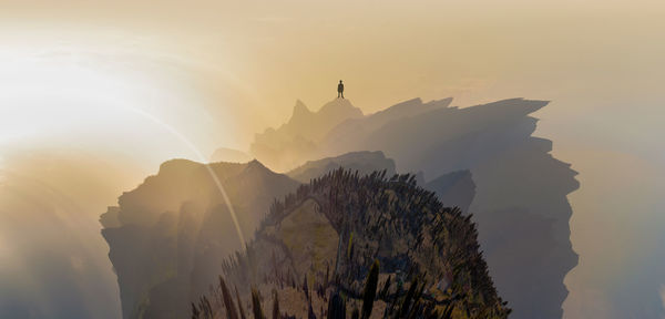 Silhouette of tree against mountain during sunset