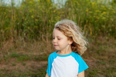 Cute girl looking away while standing on land