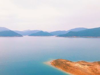 Scenic view of sea and mountains against sky