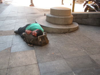High angle view of man sleeping on sidewalk