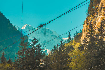 Overhead cable cars against sky