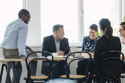 Multi ethnic business people discussing at table during meeting