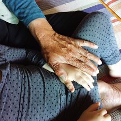 Midsection of grandmother and granddaughter at home