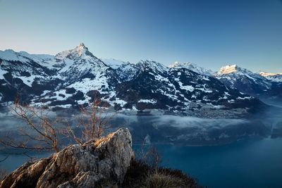 Scenic view of snowcapped mountains against clear blue sky