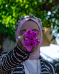 Close-up of woman holding purple flowers