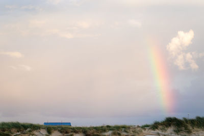 Rainbow over landscape against sky