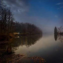 Scenic view of lake in forest against sky