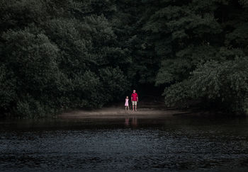 FULL LENGTH OF MAN WITH UMBRELLA ON WATER