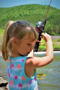 Close-up of cute girl fishing in river