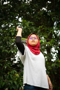 Young hijab asian girl with badminton racket at the park.