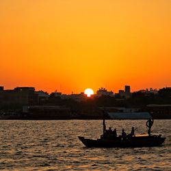 Boat in sea at sunset