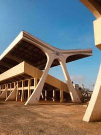 Low angle view of bridge on field against clear blue sky